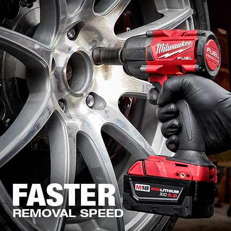 Mechanic wearing glove uses Milwaukee mid-torque impact gun to quickly remove lug nuts off a tire